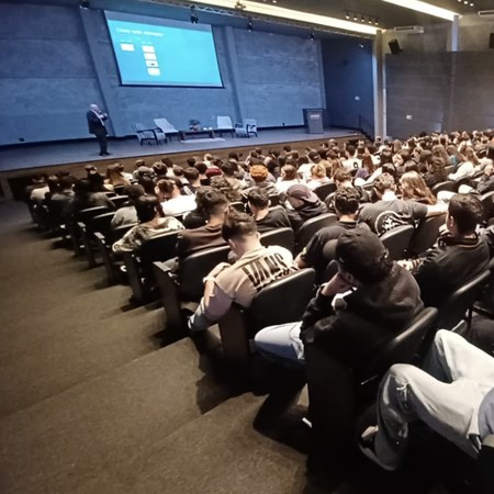 Ernesto Haberkorn palestrando para um auditório cheio de jovens